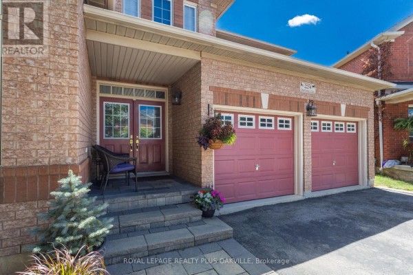 Detailed view of the front porch entrance with double doors, a seating area, and a double garage. - 2254 Dunforest Crescent, Oakville