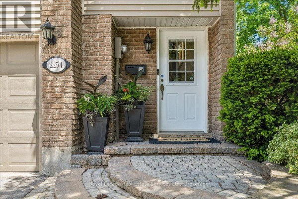 Living room with fireplace, television, bay window, and hardwood floors. - 2254 Marine Drive, Oakville