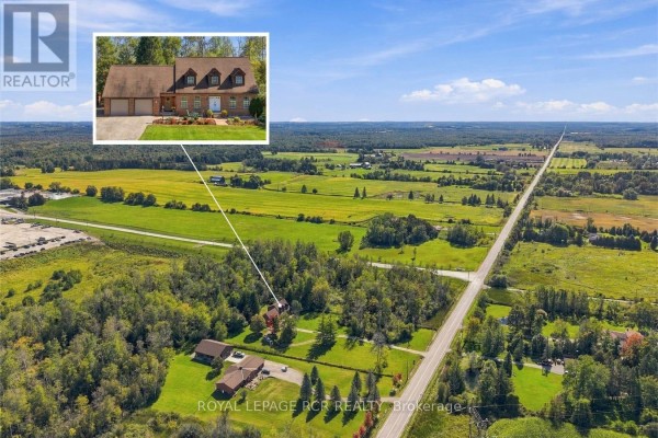 Aerial view of the house at 22541 Kennedy Road, surrounded by trees and farmland. - 22541 Kennedy Road, East Gwillimbury