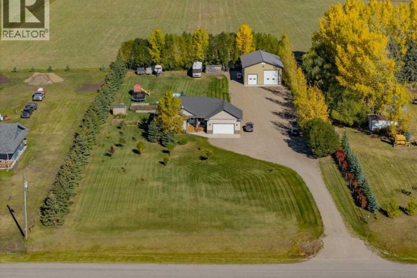 View of the residential property from the front, featuring the house, driveway, and landscaping. - 2256 Township Road 334, Rural Mountain View County