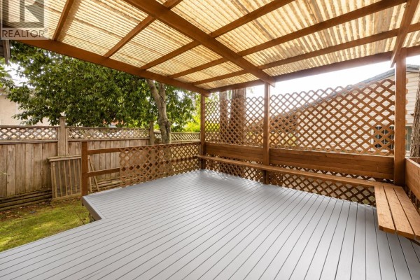 Living room with a sectional sofa, coffee table, and sliding glass doors to a deck. - 2259 Central Avenue, Port Coquitlam