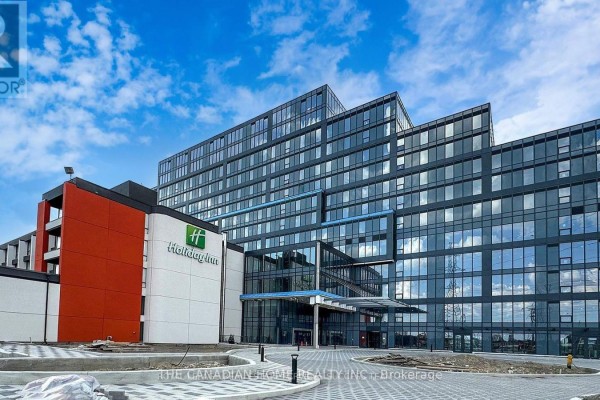 Exterior view of a modern glass-faced building with an adjacent Holiday Inn hotel. - 226 - 600 Dixon Rd Road, Toronto