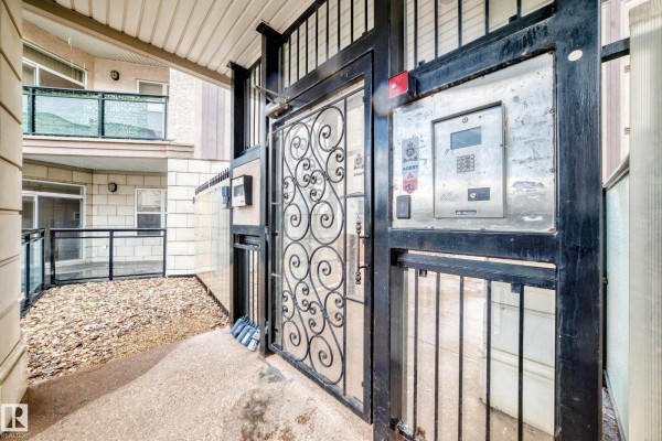 A metal outdoor elevator with ornate gate and intercom system beside a building. - #226 4831 104a St Nw, Edmonton