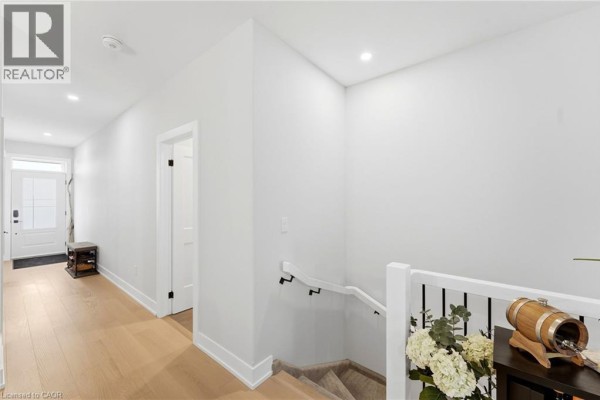 View of a staircase landing with white walls, a black banister, and light wood flooring. - 226 Lafayette Street E, Jarvis