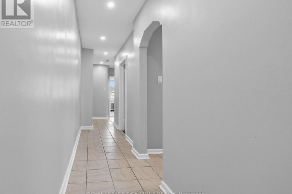 Tiled hallway with light grey walls and arched doorway to the right. - 2260 Eglinton Avenue W, Toronto