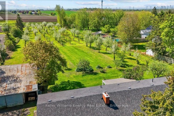 Aerial view of a property with multiple buildings, trees, and a highway. - 2263 Hwy 2, Clarington