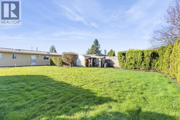 Side view of the house with carport and green lawn - 22641 Brown Avenue, Maple Ridge