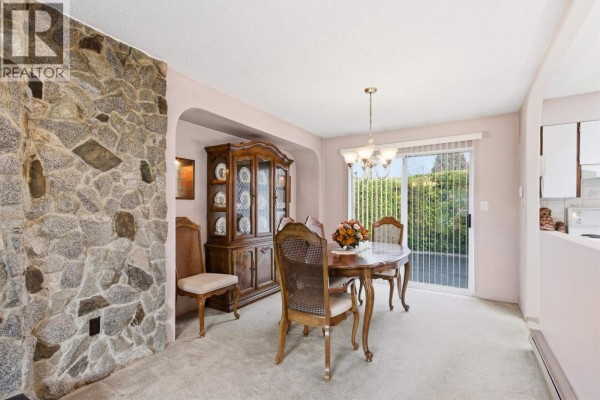Living room featuring stone fireplace and adjacent dining area - 22641 Brown Avenue, Maple Ridge
