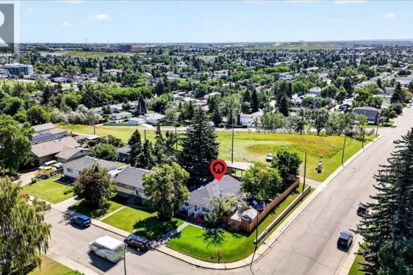 Aerial view of a residential neighborhood showing a bungalow with a red roof and surrounding properties. - 227 Lynnwood Drive Se, Calgary