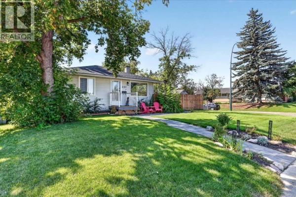 Street view of a one-story home with a well-maintained lawn, stone pathway, and mature trees. - 227 Lynnwood Drive Se, Calgary