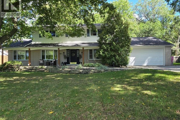 Front view of a residential house featuring a wide covered porch and manicured lawn. - 22707 Creek Road, Chatham