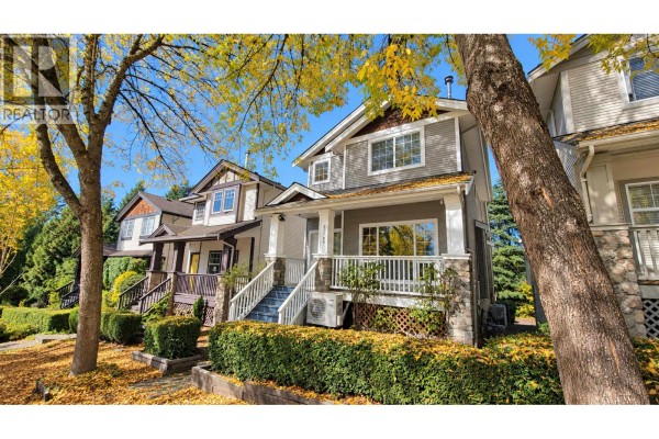 Side view of a home with grey siding, white trim, stone accents, and a covered porch with stairs. - 22789 116 Avenue, Maple Ridge