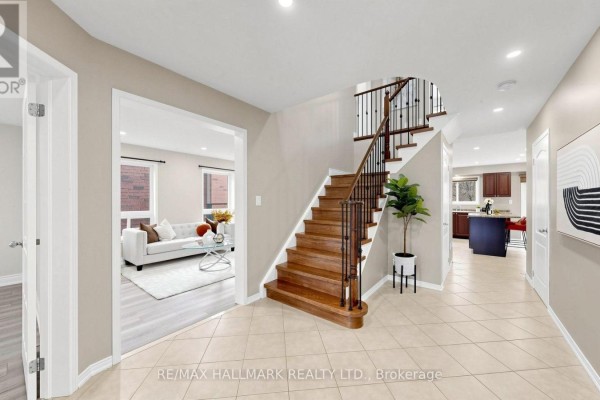 View from entryway into living room with white sofa and kitchen with dark cabinets and red island. - 2279 Hackett Place, Oshawa