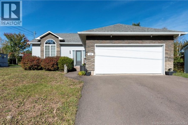 Front view of a residential house with grey siding, a stone facade, and a double garage door. - 228 Herve Street, Dieppe