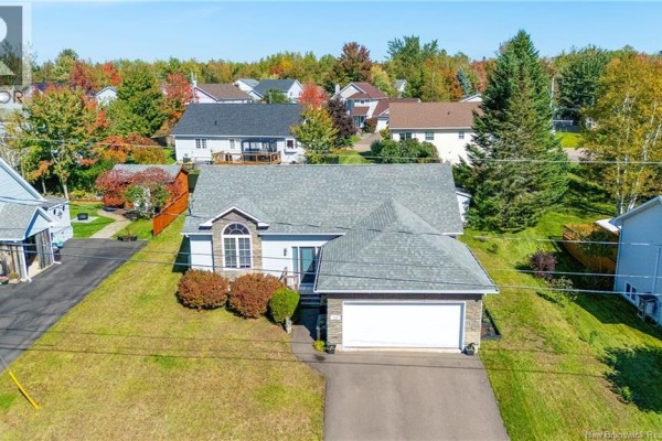 Front exterior of a one-story house with a sloped roof and surrounding trees in autumn colors. - 228 Herve Street, Dieppe