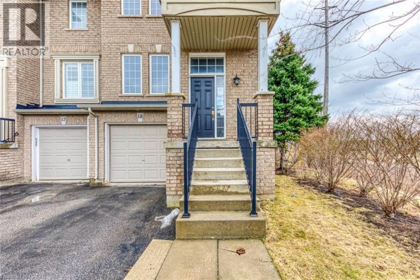 Close-up of townhouse entrance with dark blue door and stairs. - 2280 Baronwood Drive Unit# 18, Oakville