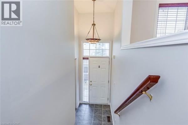 Interior view of a foyer with white door, window, and chandelier. - 2280 Baronwood Drive Unit# 18, Oakville