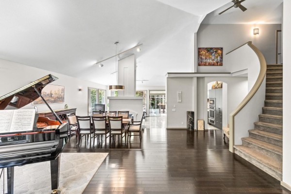 Foyer area with double doors, leading to a large living and dining space with a piano. - 2289 131a Street, Surrey