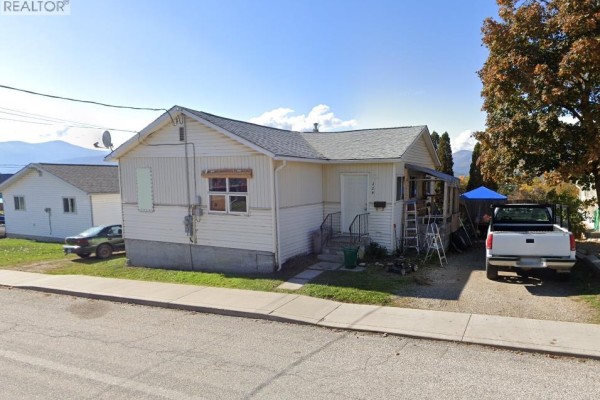 Side view of a white sided house with RV and pickup truck parked. - 229 9th  S Avenue, Creston