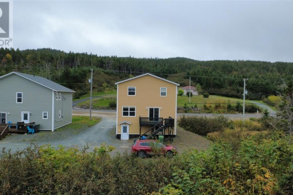 Aerial view of a street with several houses and a body of water in the distance. - 229 Marine Drive, Marystown