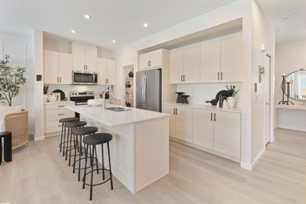 Kitchen island with seating and views into the living and dining area. - 22926 93a Av Nw, Edmonton