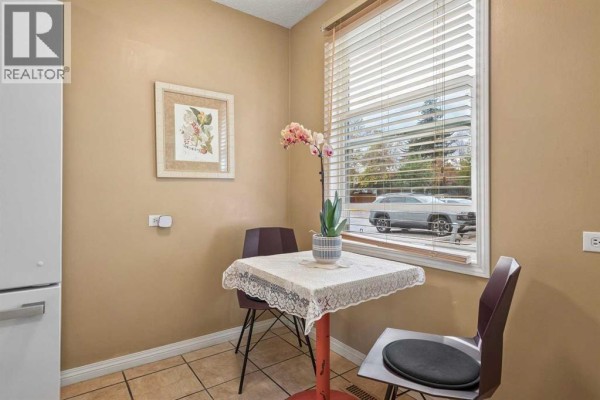 Small dining nook with table and two chairs by a window. - 23, 330 Canterbury Drive Sw, Calgary