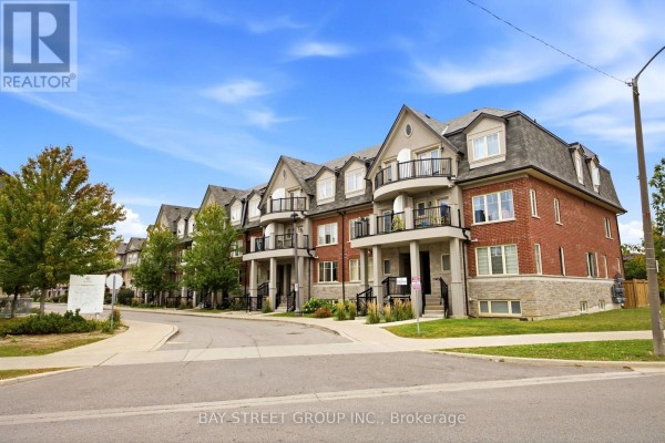 Exterior front view of a brick townhouse building with multiple balconies and dormer windows. - 23 - 1 Eaton Park Lane E, Toronto