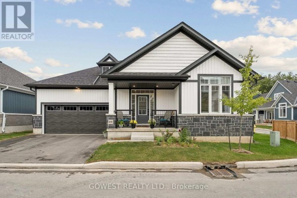 Front view of a modern white house with black trim, a dark grey garage door, and a covered entrance porch. - 23 - 2797 Red Maple Avenue, Lincoln