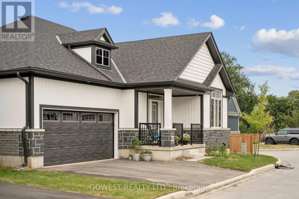 Close-up side view of a modern white house with black trim, showing the garage door and front porch details. - 23 - 2797 Red Maple Avenue, Lincoln