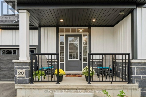 Close-up view of the covered front porch with a gray door, black railings, and two chairs with cushions. - 23 - 2797 Red Maple Avenue, Lincoln