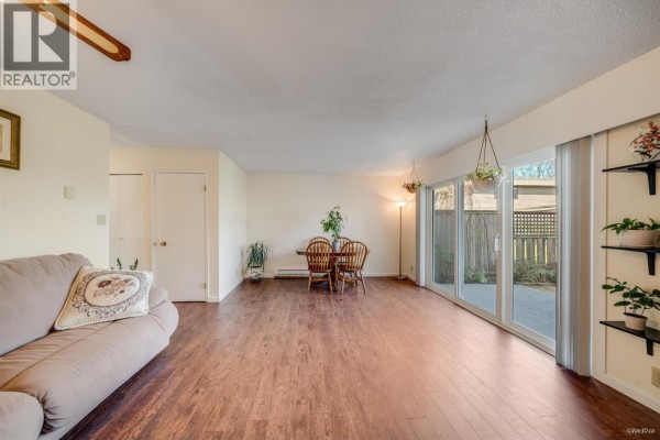 Open living area with sofa, hardwood floors, and natural light from sliding doors - 23 10840 Springmont Drive, Richmond