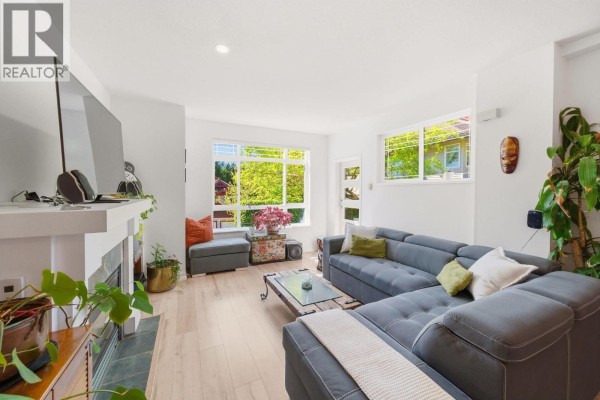 View of a large window in the living room with trees and foliage visible outside. - 23 15 Forest Park Way, Port Moody