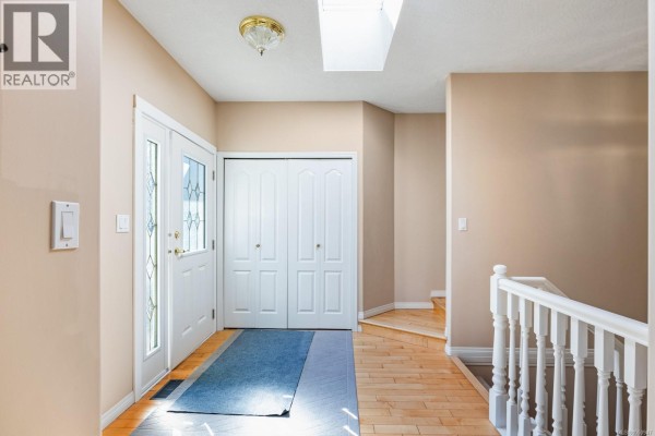 Interior entryway with light wood floors, white bi-fold doors, and a staircase. - 23 1700 Pritchard Rd, Cowichan Bay