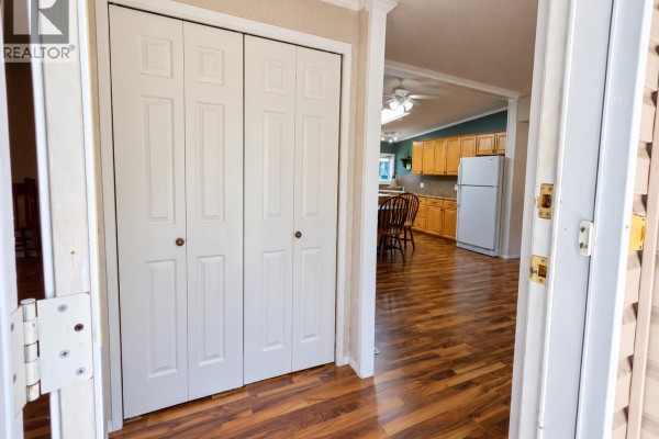 Kitchen island with gas range and wooden cabinets. Living room visible. - 23 6820 Parklands Pl, Lantzville