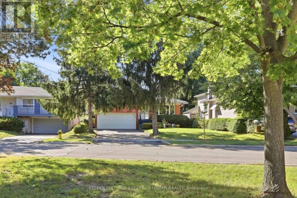 Street view of the bungalow with adjacent homes and mature trees. - 23 Banstock Drive, Toronto