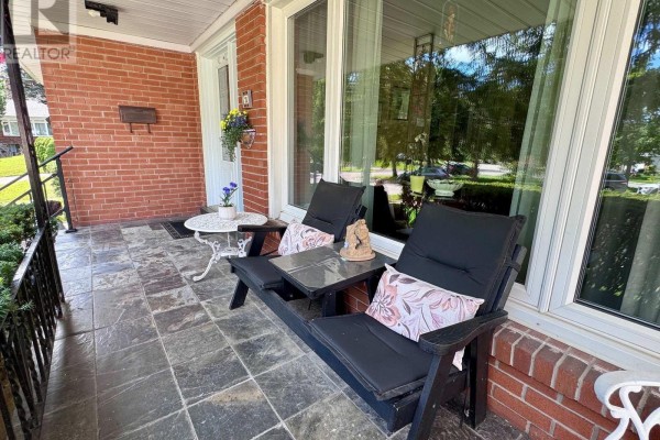 Front porch with slate tiles, seating, and a small table. - 23 Banstock Drive, Toronto