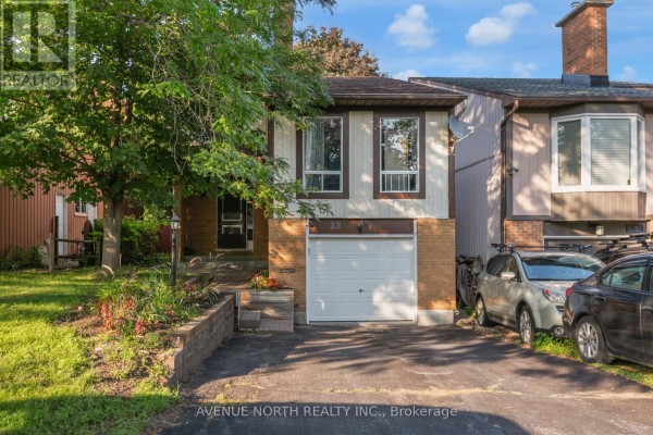 Slightly angled front view of a house with a driveway, lawn, and walkway to the front door. - 23 Bluegrass Drive, Ottawa