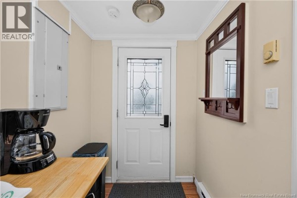 Entryway with a coffee maker, wood laminate floor, and a frosted glass door. - 23 Clover Lane, Pointe Du Chene