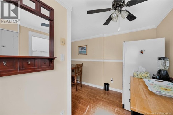 View into a kitchen area with a refrigerator, dining table, and chairs. - 23 Clover Lane, Pointe Du Chene