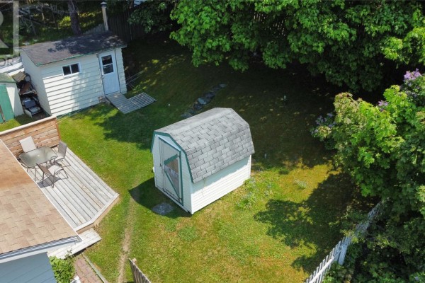 Wooden deck with patio furniture and a barbecue beside the rear entrance of a house. - 23 Diana Road, St  John S