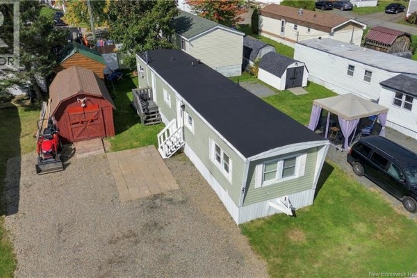Elevated panoramic view of a dense mobile home community surrounded by vibrant fall foliage and forests. - 23 Douglas Crescent, New Maryland