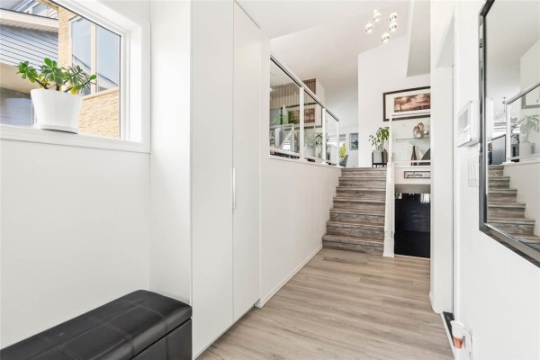 View of the entryway leading to a staircase with laminate treads and glass railing. - 23 Driftwater Trail, Winnipeg