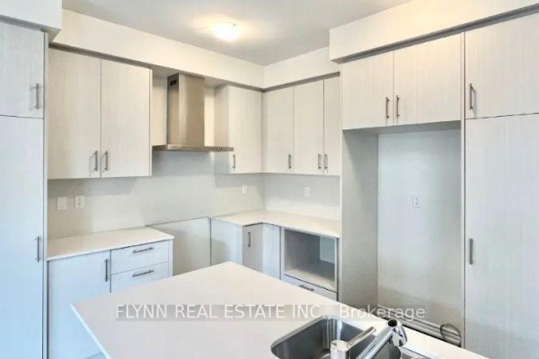 Modern kitchen with white cabinets, stainless steel range hood, and white quartz countertops. - 23 Gemini Drive, Barrie