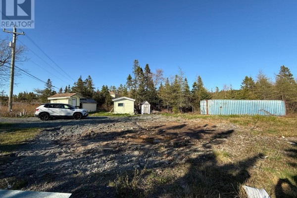 Several small utility buildings and a blue shipping container on a cleared lot with trees in background. - 23 Hodgewater Line, South River