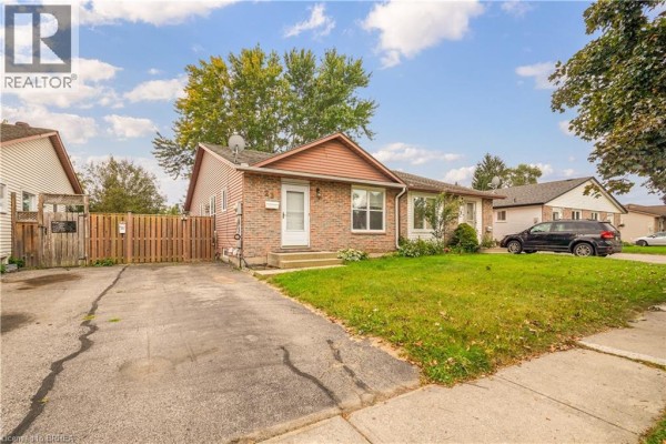 View of the brick bungalow from the driveway showing a black SUV parked on the street. - 23 Palomino Drive, Brantford