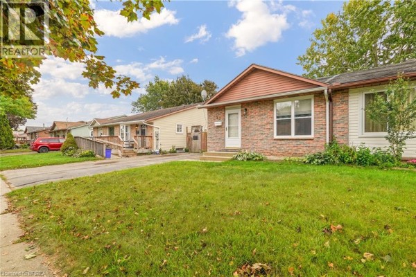 Side view of the bungalow with a paved driveway and neighboring properties. - 23 Palomino Drive, Brantford