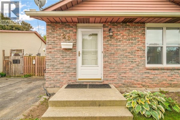 Close-up of the front entrance with a white door, brick facade, and concrete steps. - 23 Palomino Drive, Brantford
