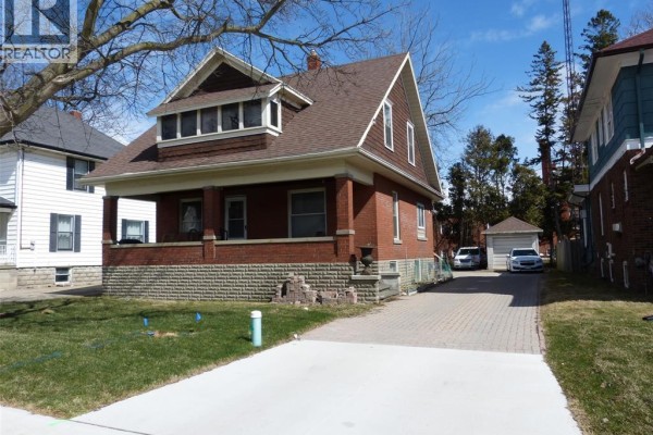 Side view of the house featuring a brick exterior and driveway leading to the garage. - 23 Queeens Avenue, Leamington