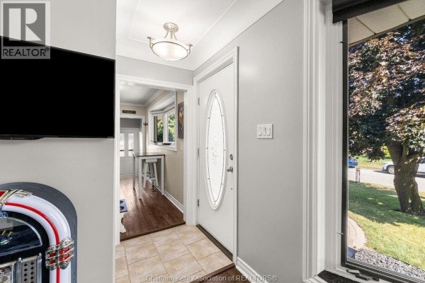 Interior entryway with light grey walls, tiled floor, and a white door. - 23 Queensway Drive, Chatham