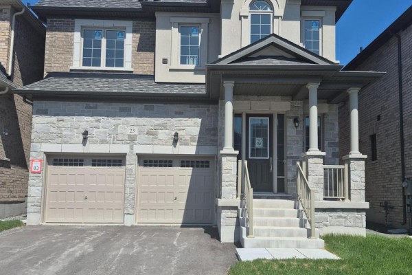 Close-up of the front entrance of a house with stone facade and two garage doors. - 23 Rogerson Street, Clarington